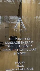 Artemis Wellness Clinic front window listing acupuncture, massage therapy and physiotherapy