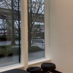 Treatment room with a street-facing window, treatment table and stools