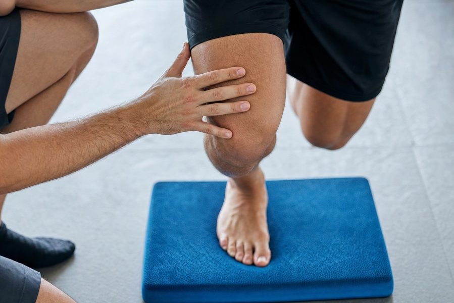 Knee proprioception training on balance pad close-up — ski/snowboard season prep