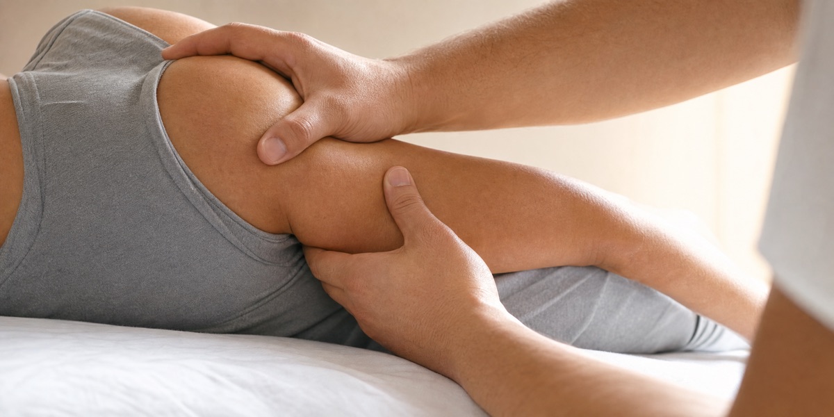Osteopath gently mobilizing a patient's shoulder during an osteopathy treatment session at Artemis Wellness Clinic Richmond BC