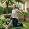 Gardener kneeling on a pad in a Richmond BC backyard garden, pausing with a hand on her lower back — gardening back pain recovery, Artemis Wellness Clinic